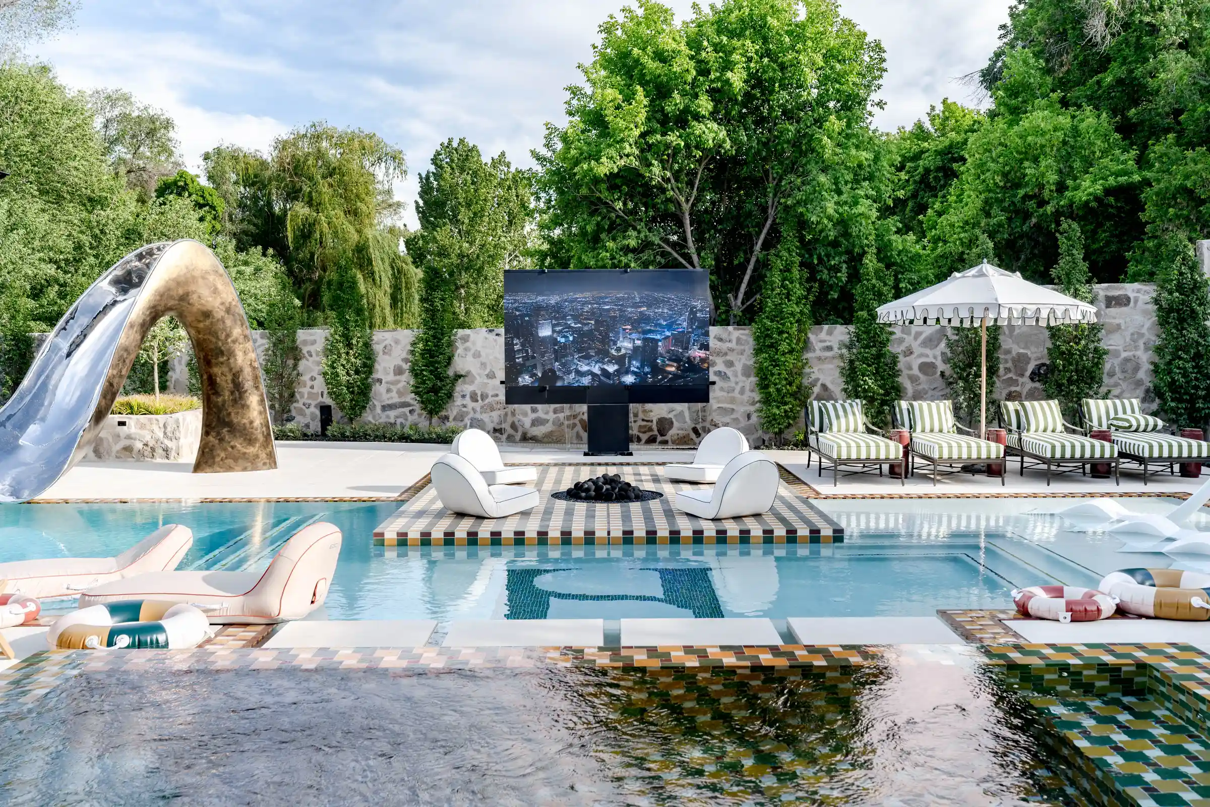 Zero-edge pool, sculptural slide, fire feature, and pavilion at Modern Elm