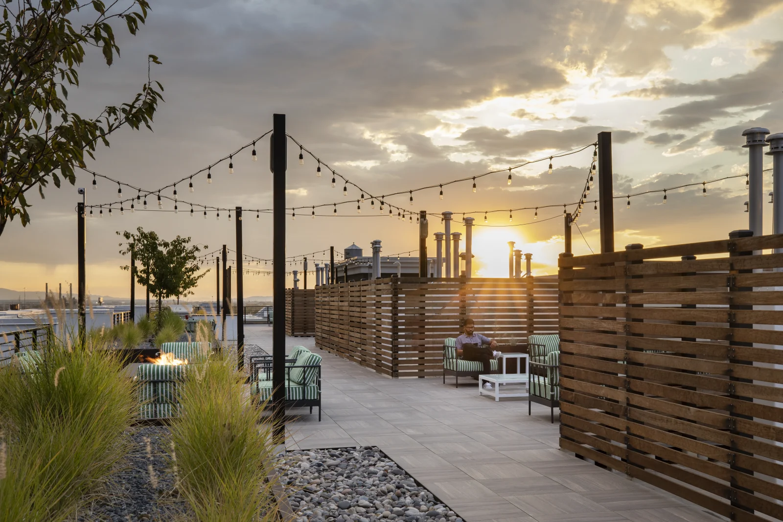 Wood screen fencing softening the steel and glass backdrop at sunset
