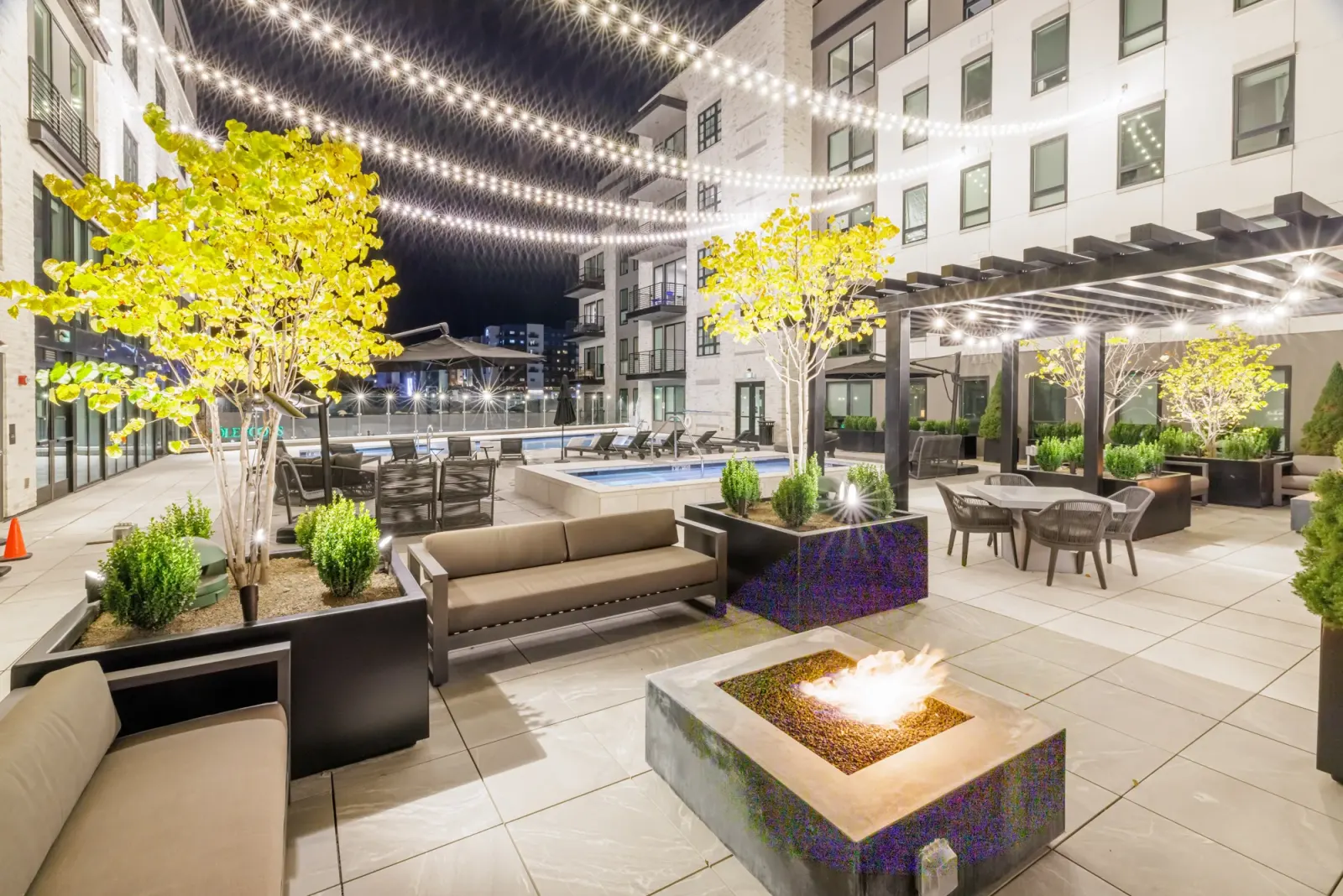 Sugar Alley courtyard at dusk with fire feature, pool and pavilion
